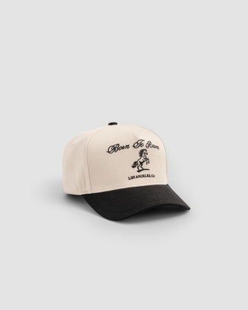 Born To Roam American Trucker Cap in creme, a classic baseball cap with mesh back and adjustable strap.