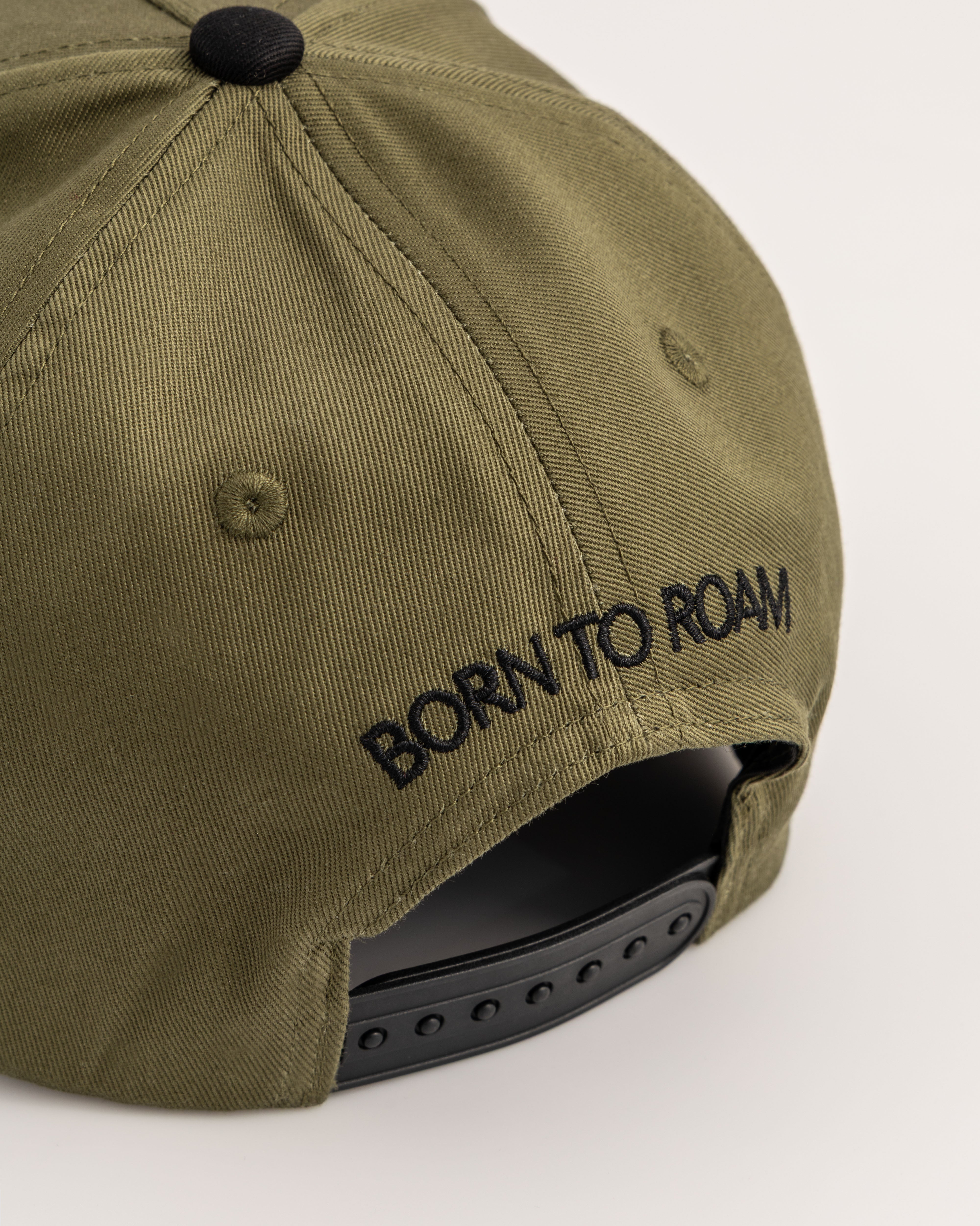 Born To Roam American Trucker Cap in olive green, classic baseball cap with mesh back and adjustable strap.