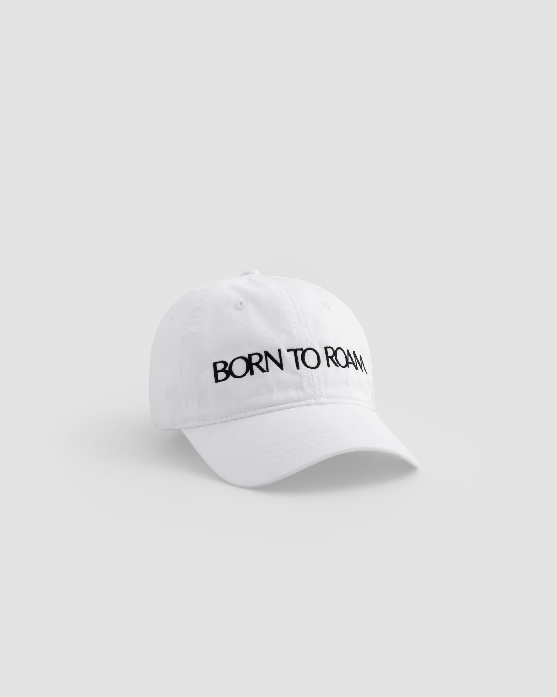 Born To Roam Queens Baseball Cap in classic white, featuring a structured brim and adjustable strap for a casual outdoor look.