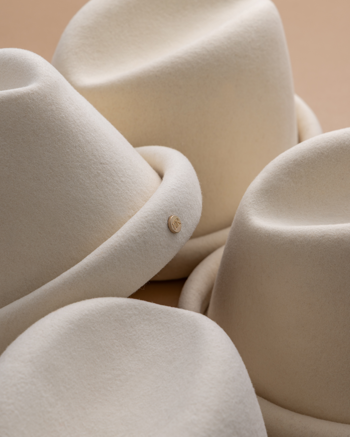 Ivory Russian pillbox hat by Born To Roam featuring a sleek, rounded style with a subtle decorative band.