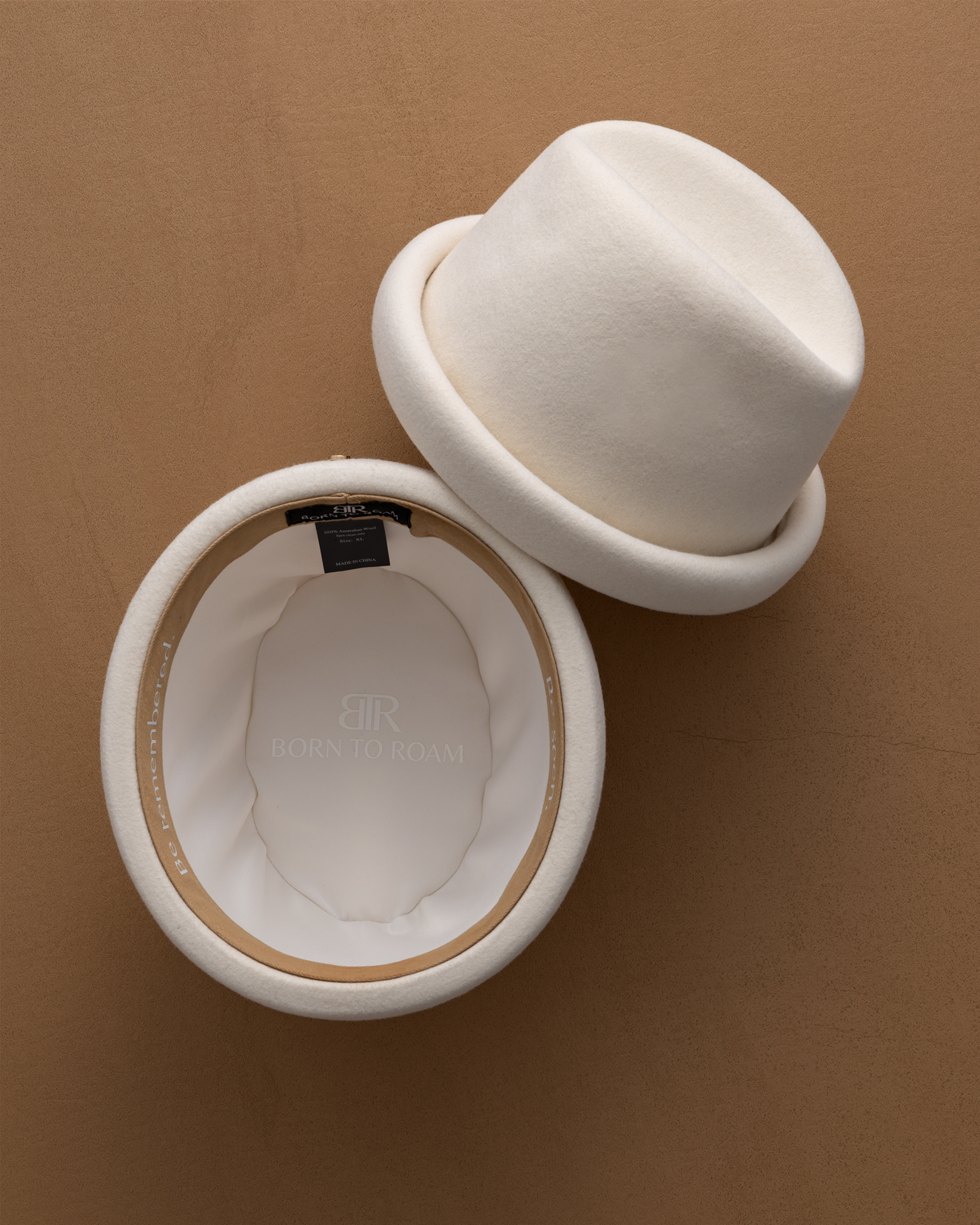 Ivory Russian pillbox hat by Born To Roam, featuring a sleek, structured design perfect for stylish accessories.