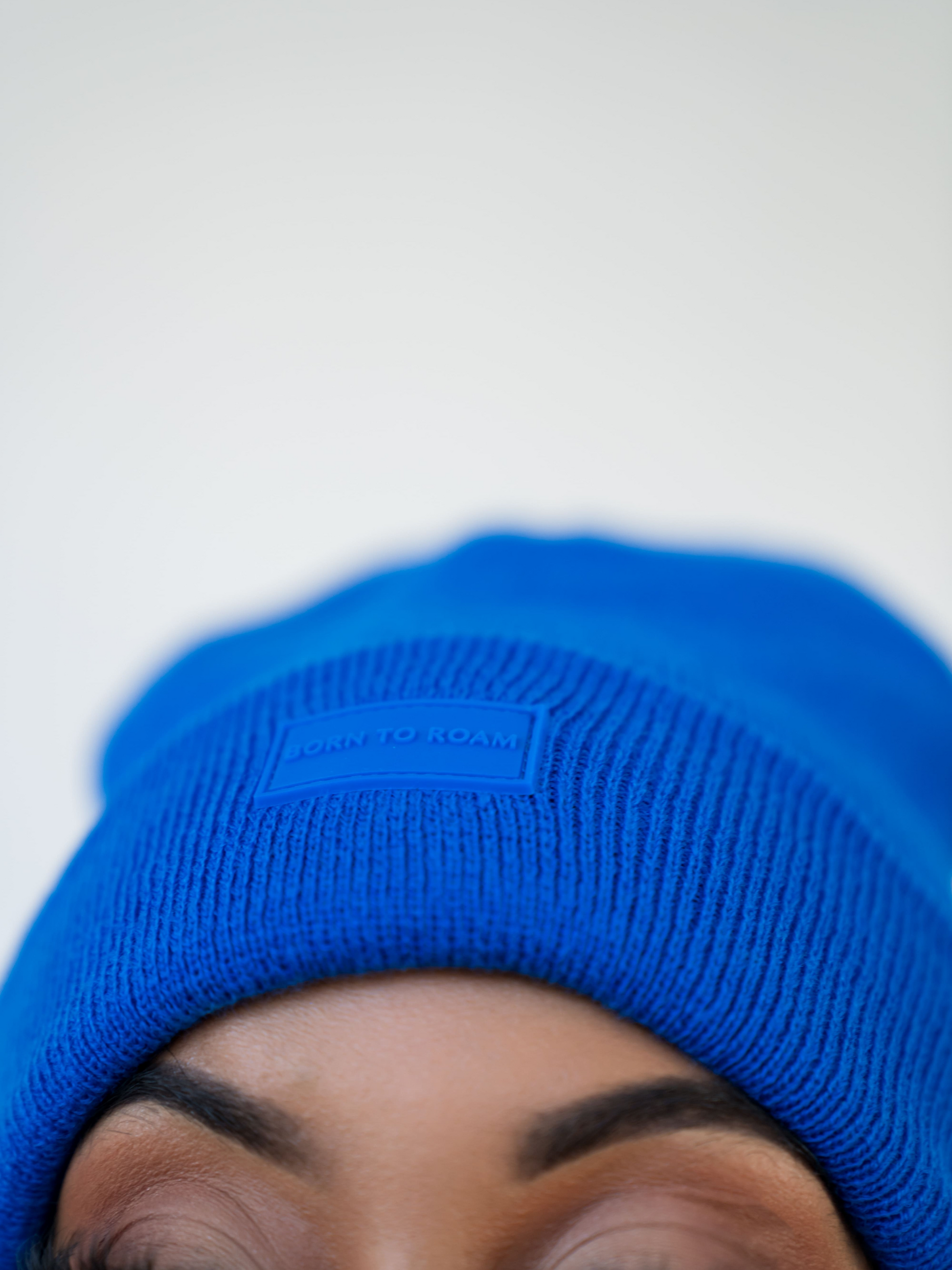 Cobalt blue Vail Knit Beanie by Born To Roam, showcasing a cozy, stretchy knit fabric and snug fit for winter warmth.