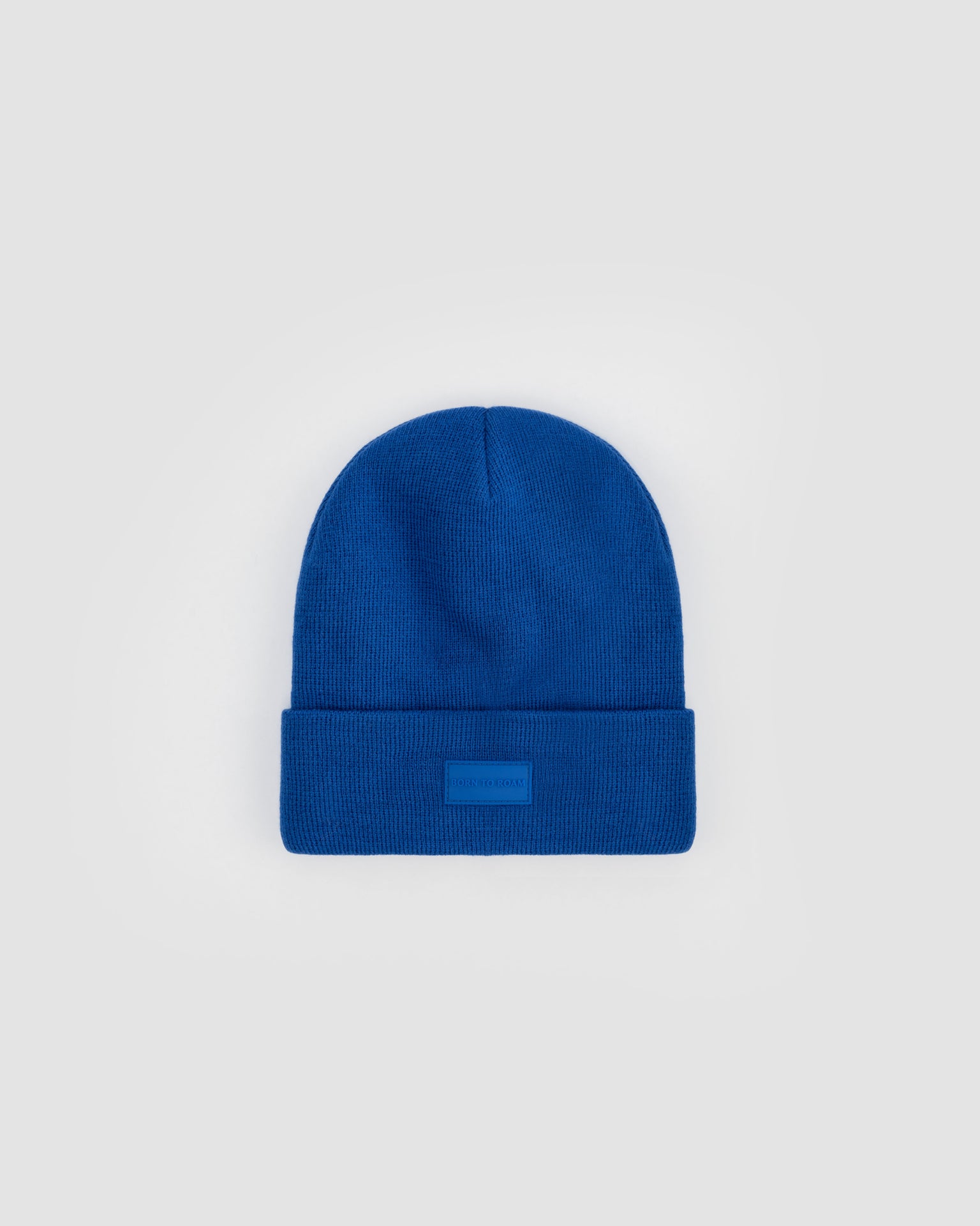 Born To Roam Vail Knit Beanie in vibrant cobalt blue, soft knit fabric, snug fit, perfect for cold weather.