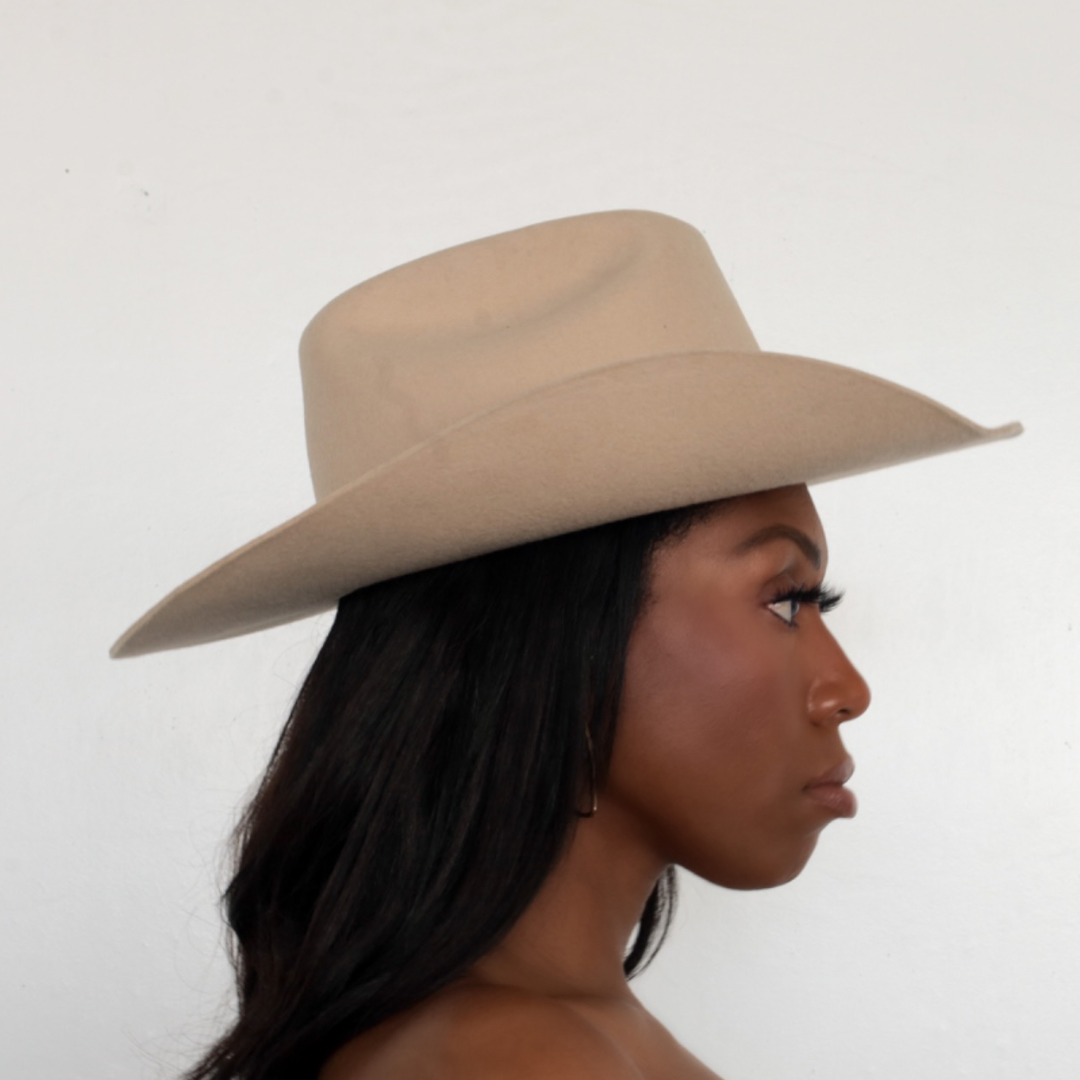 BornToRoam - women posing by wearing Upland Cattleman Cowboy Hat in Tan color side view